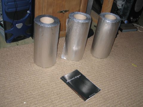 1996 Ford Crown Victoria - Three rolls of insulation material and a booklet are on a carpeted floor.
