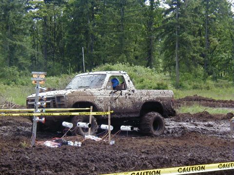 1985 Ford Bronco - This truck is covered in mud after an off-road event. The body style suggests it is from the 1980s.