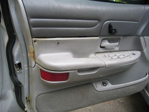 1996 Ford Crown Victoria - Close-up of a car's interior door panel, showing the window controls and armrest area.