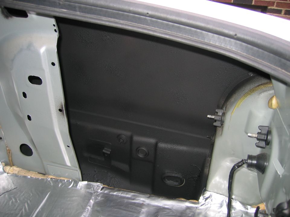Trunk interior with sound deadening material and exposed metal
