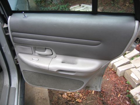 1996 Ford Crown Victoria - Interior view of a car door panel, showing the gray upholstery and controls.