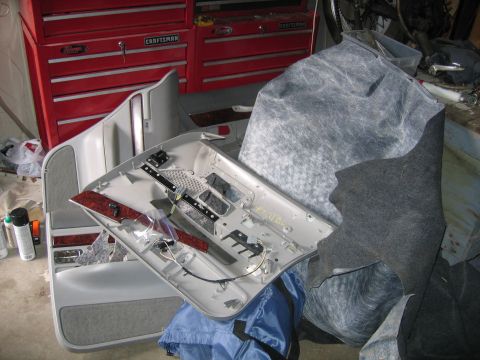 1996 Ford Crown Victoria - A car door panel and insulation are laid out, with a red tool chest visible in the background.