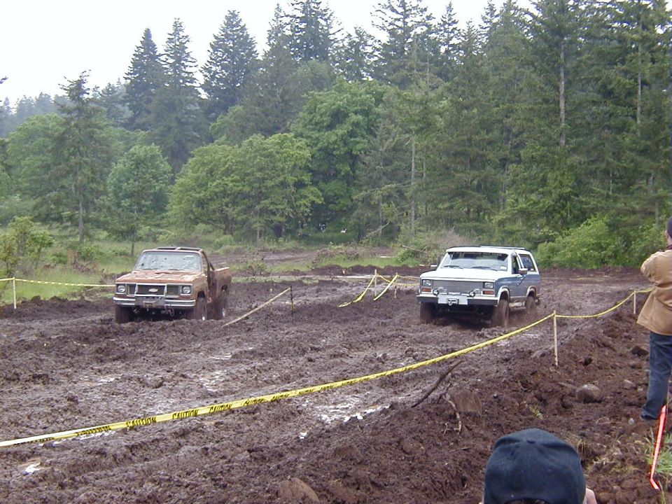 Two SUVs navigating a muddy off-road course