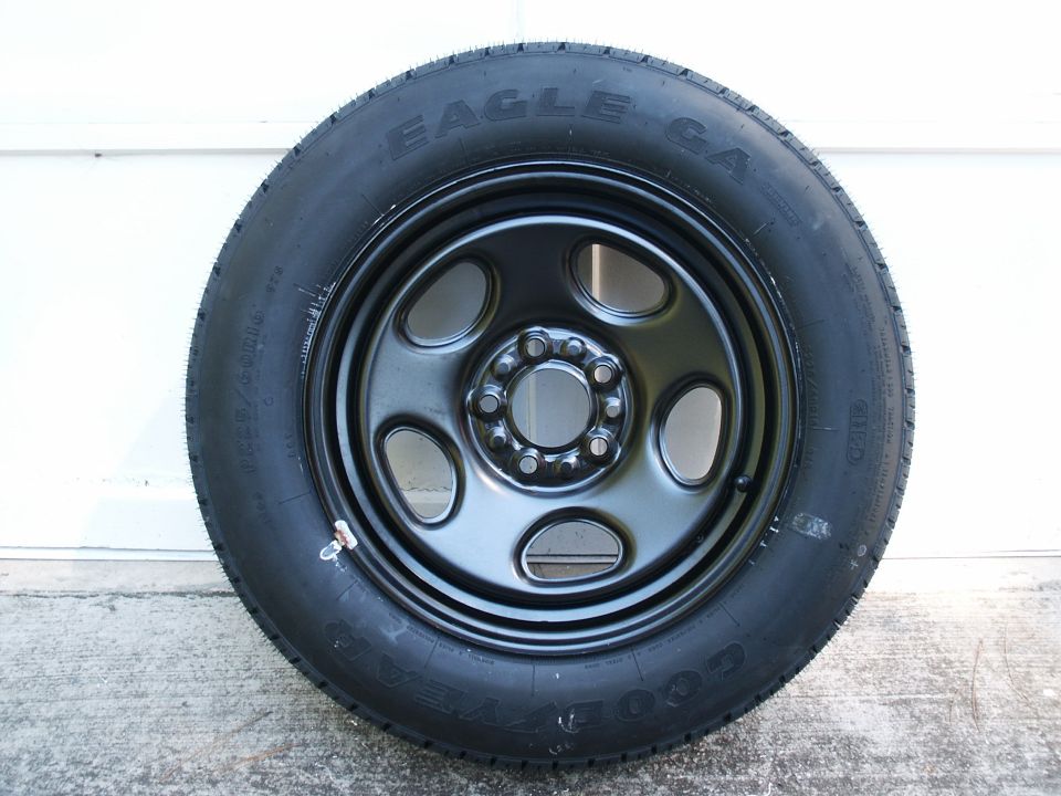 Black steel wheel with Goodyear Eagle GA tire standing on concrete