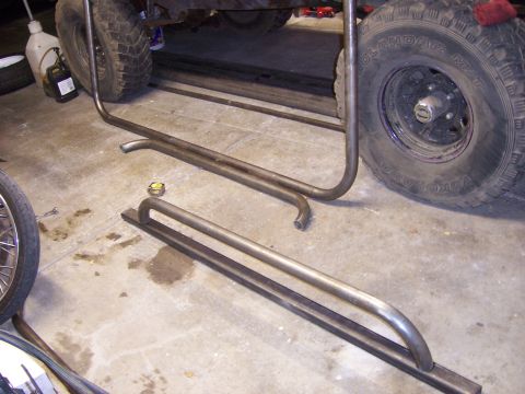 1991 Ford Bronco - Fabrication of custom rock sliders next to a vehicle's frame and tire.