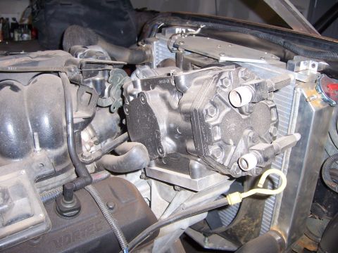 1991 Ford Bronco - Close-up of an engine bay, focusing on the AC compressor and radiator assembly.