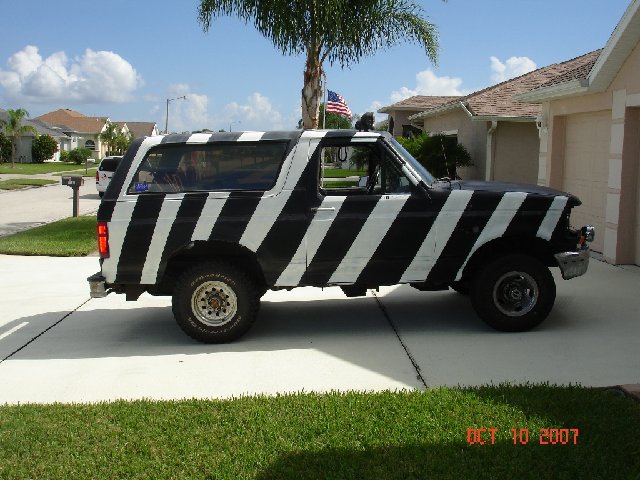 Black and white striped Ford Bronco parked on a driveway