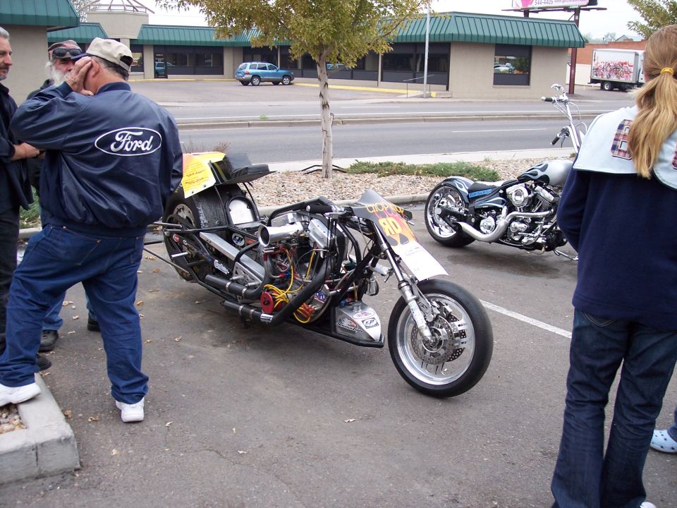Custom drag motorcycle with exposed engine and a second motorcycle in background