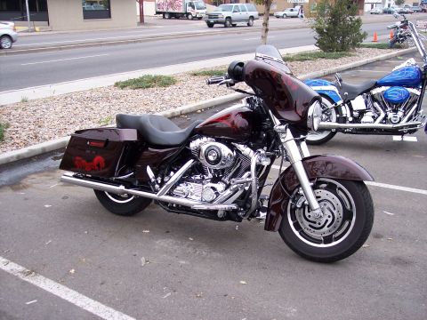 1972 Ford Ranchero - Two motorcycles parked in a lot, one is a maroon Harley-Davidson with custom paint.