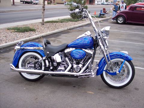 1972 Ford Ranchero - A custom blue motorcycle with flame graphics is parked in a lot next to a maroon hot rod.