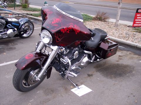 1972 Ford Ranchero - A custom motorcycle with a dark red paint job skull graphics is parked next to another motorcycle.