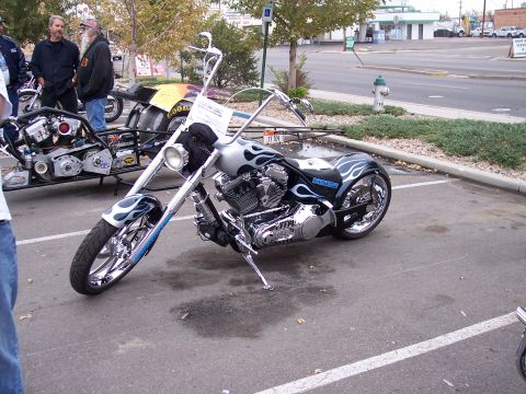 1972 Ford Ranchero - A custom chopper motorcycle with flame graphics is parked in a lot next to another vehicle.