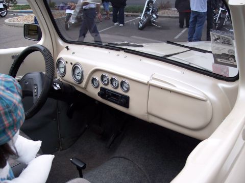 1972 Ford Ranchero - The interior of a vehicle shows a dashboard with several gauges and a radio, with a person in the foreground.