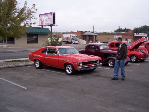 1972 Ford Ranchero - Several classic cars are parked in a lot, including a red 1970s Chevrolet Nova SS.