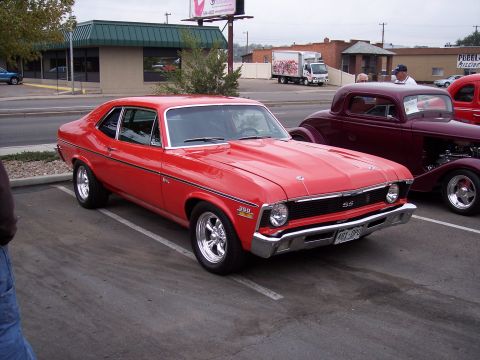1972 Ford Ranchero - A red 1969 Chevrolet Nova SS is parked next to a maroon hot rod.