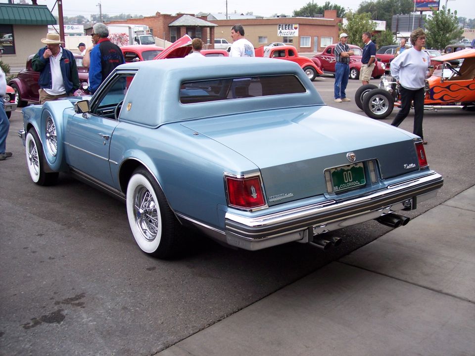 Light blue coupe with whitewall tires and wire wheels, spare tire on fender. 1977 Cadillac Eldorado