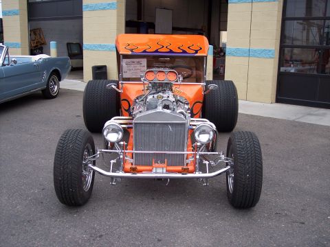 1972 Ford Ranchero - A custom-built hot rod with a prominent V8 engine is parked next to a blue classic car outside a garage.