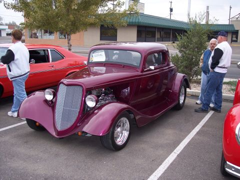 1972 Ford Ranchero - A custom coupe hot rod is parked at a car show next to other vehicles.