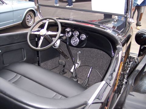 1972 Ford Ranchero - The interior of a classic black car is shown, with a light blue vehicle visible outside.