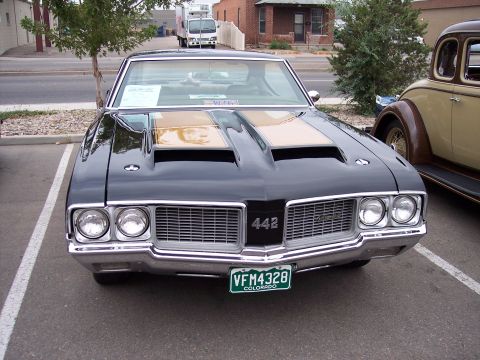 1972 Ford Ranchero - A black 1970 Oldsmobile 442 is parked in a lot next to another classic car.