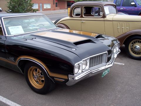 1972 Ford Ranchero - Front view of a black 1970 Oldsmobile 442 next to a vintage tan coupe.