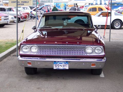 1972 Ford Ranchero - A maroon 1972 Ford Ranchero is parked at a car show, displaying its classic front end and chrome grille.