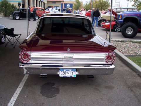 1972 Ford Ranchero - A classic maroon Ford Falcon is parked at an outdoor car show with other vehicles visible in the background.