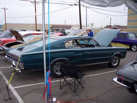 1972 Ford Ranchero - A 1966 Dodge Charger is displayed with its hood open at an outdoor event, alongside other vehicles.
