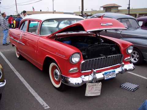 1972 Ford Ranchero - A red and white 1955 Chevrolet sedan is displayed with its hood open at an outdoor event.