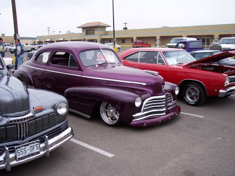 1972 Ford Ranchero - Three classic cars are parked in a lot, including a 1949 Mercury and a custom coupe.