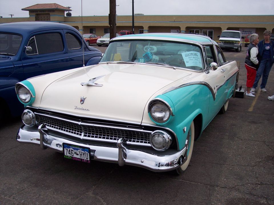 1955 Ford Fairlane Crown Victoria, two-tone white and teal, parked next to a blue car