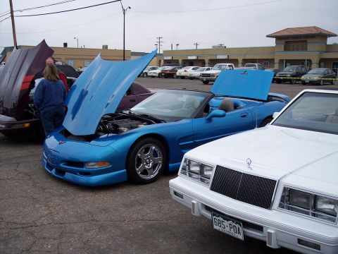 1972 Ford Ranchero - A blue convertible sports car is parked with its hood open, alongside other vehicles at an outdoor event.