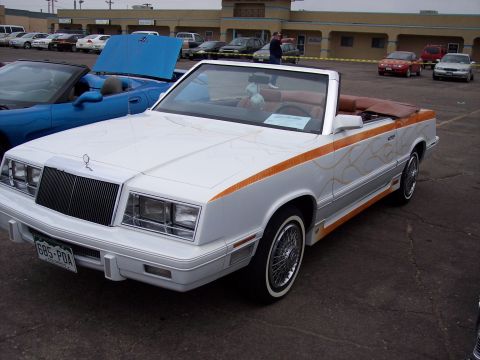1972 Ford Ranchero - A customized white convertible with flame graphics is parked in a lot next to a blue convertible.