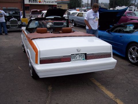 1972 Ford Ranchero - A white convertible with wood paneling is parked next to a blue sports car.