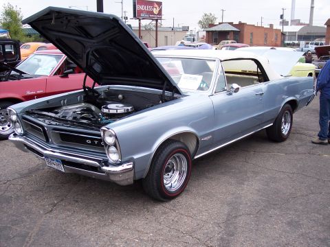 1972 Ford Ranchero - A light blue 1965 Pontiac Tempest convertible is displayed with its hood open, revealing the engine bay.