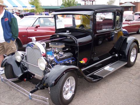 1972 Ford Ranchero - Customized black coupe, possibly a 1930s model, displayed at a car show with other vehicles.