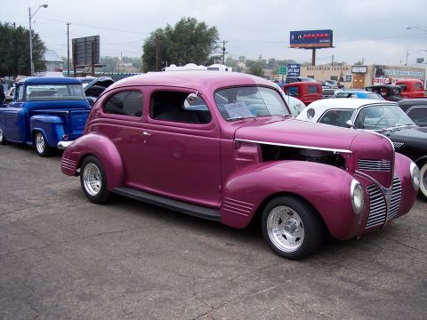1972 Ford Ranchero - A row of cars, including a purple 1939 Plymouth sedan and a blue pickup truck, are parked outdoors.