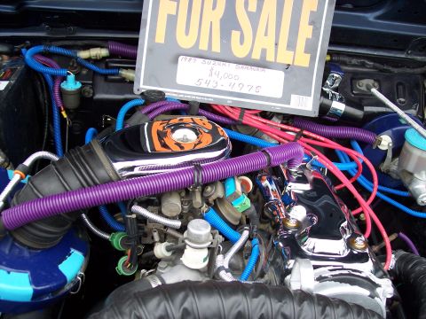 1972 Ford Ranchero - The engine bay is filled with colorful wiring and hoses, with a sign indicating the vehicle is for sale.