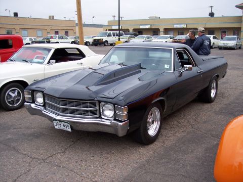 1972 Ford Ranchero - A black 1972 Ford Ranchero is parked next to a white convertible at a car show.
