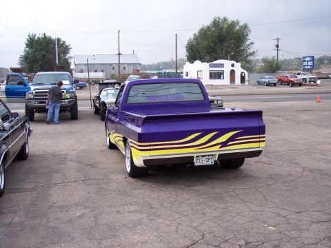 1972 Ford Ranchero - Customized pickup truck with flame graphics parked outdoors with other vehicles.