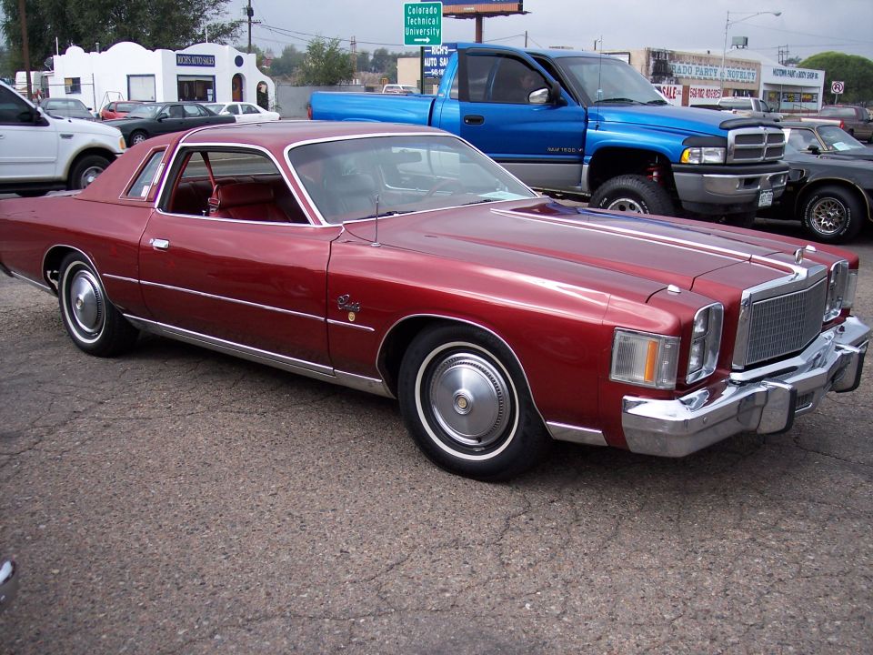Red 1977 Chrysler Cordoba coupe with white stripes and chrome trim