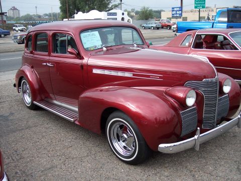 1972 Ford Ranchero - Red 1939 Chevrolet Master Deluxe sedan parked next to a red coupe and a blue pickup truck.