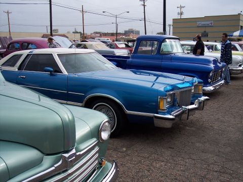 1972 Ford Ranchero - Several classic vehicles are lined up at an outdoor event, including a blue coupe and a blue pickup.