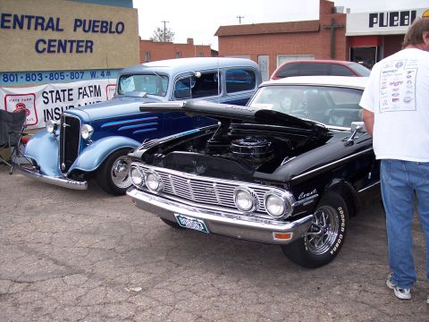 1972 Ford Ranchero - 1963 Mercury Comet shows its engine bay, parked beside a vintage blue sedan.