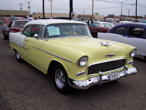 1972 Ford Ranchero - A classic yellow and white Chevrolet is parked at an outdoor car show with other vehicles visible.