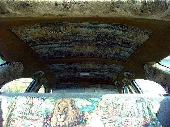 Interior view of a car with custom upholstery on the headliner and seat covers animal prints and a lion
