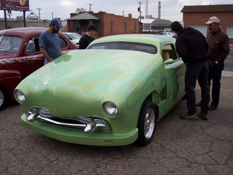 1972 Ford Ranchero - A customized green coupe with flame graphics draws attention from onlookers at an outdoor event.
