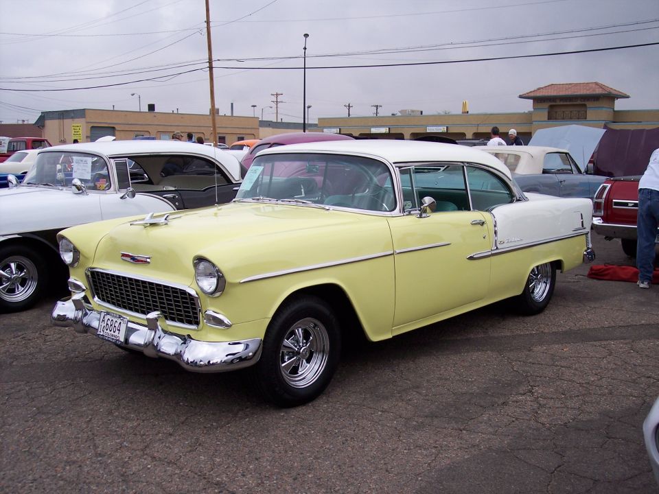 Yellow and white 1955 Chevrolet Bel Air coupe parked at a car show
