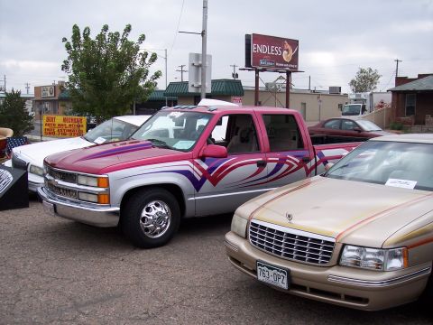1972 Ford Ranchero - A customized pickup truck with vibrant graphics is parked alongside other vehicles.