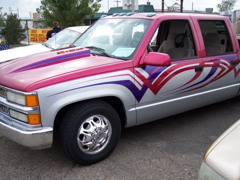 1972 Ford Ranchero - This custom pickup truck features a vibrant pink and silver paint scheme with bold graphics and dual rear wheels.
